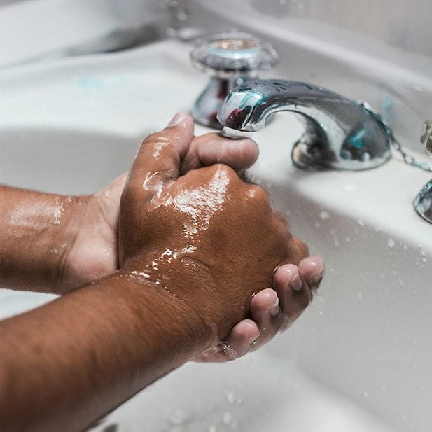 Persona che si lava le mani nel lavandino 