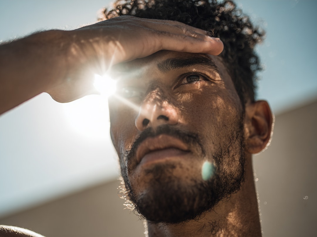 Un uomo si ripara gli occhi dalla luce del sole